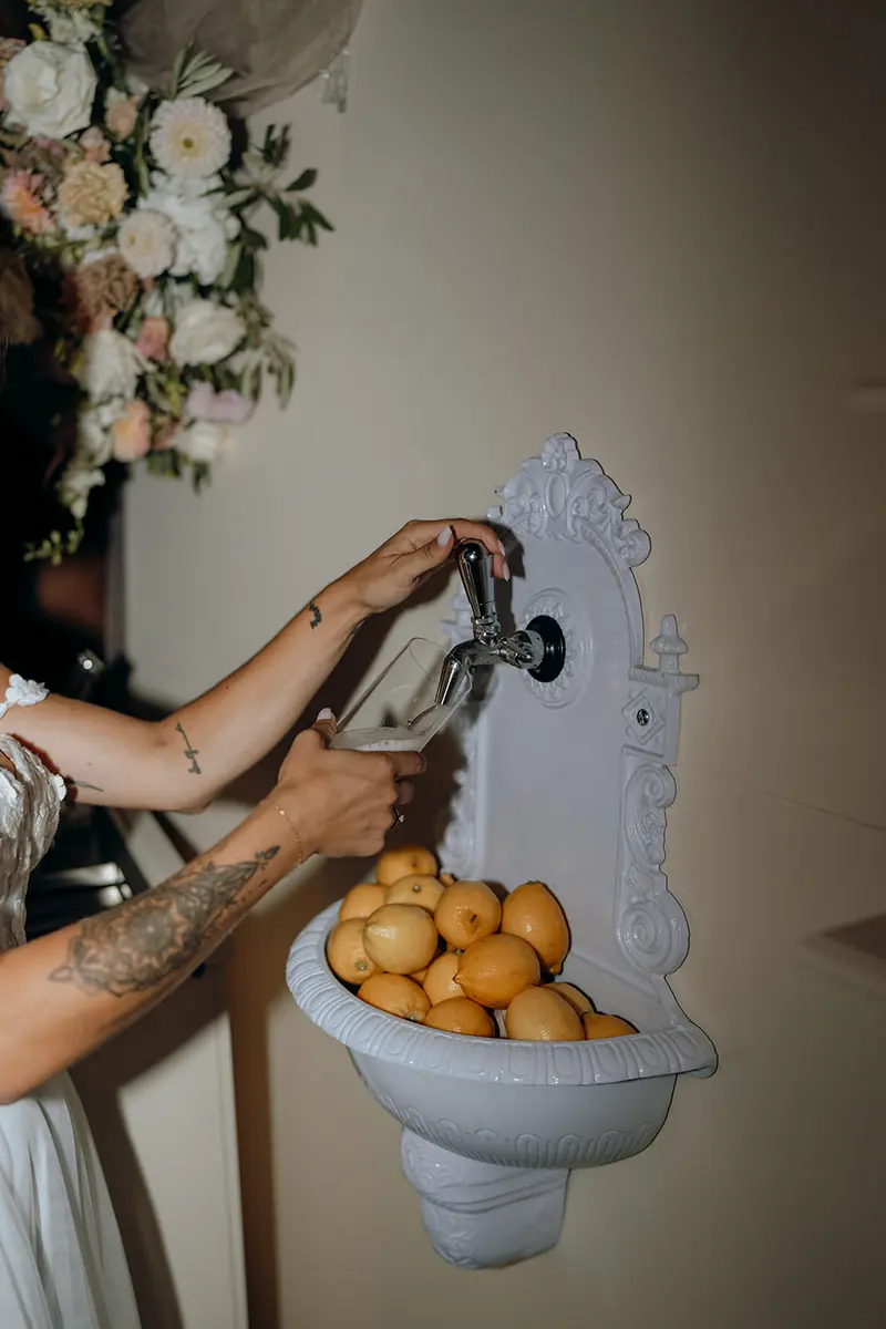 Bride pouring a cocktail at the Bride & Groom cocktail wall fountain